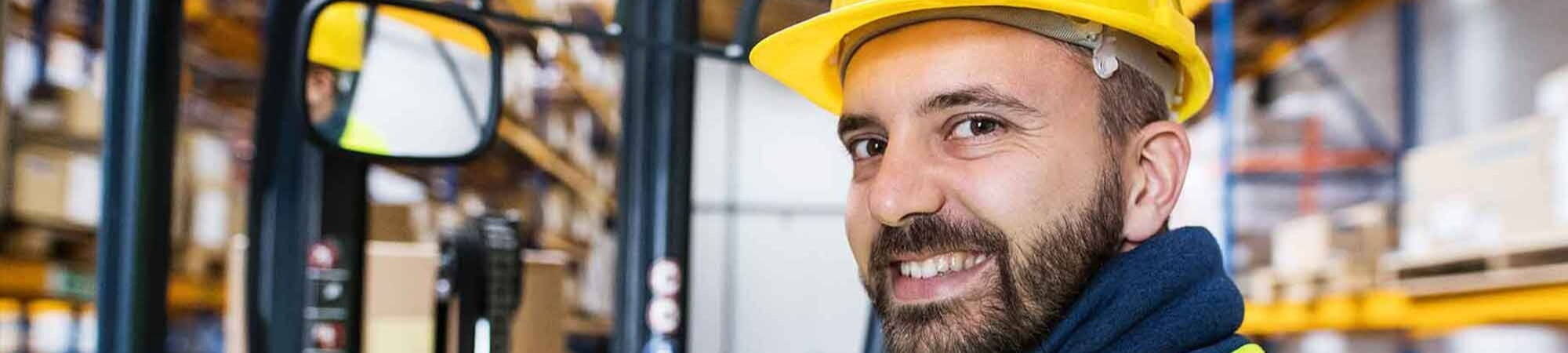 forklift driver smiling at camera after submitting timesheet